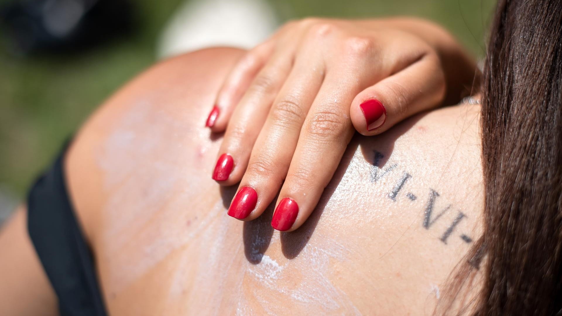 Eine Frau cremt sich mit Sonnencreme ein: Vor allem die Haut braucht im Sommer Schutz.