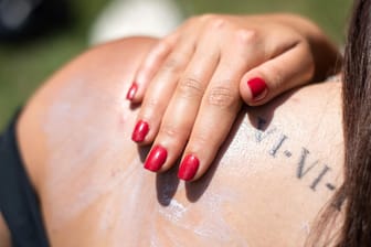 Eine Frau cremt sich mit Sonnencreme ein: Vor allem die Haut braucht im Sommer Schutz.