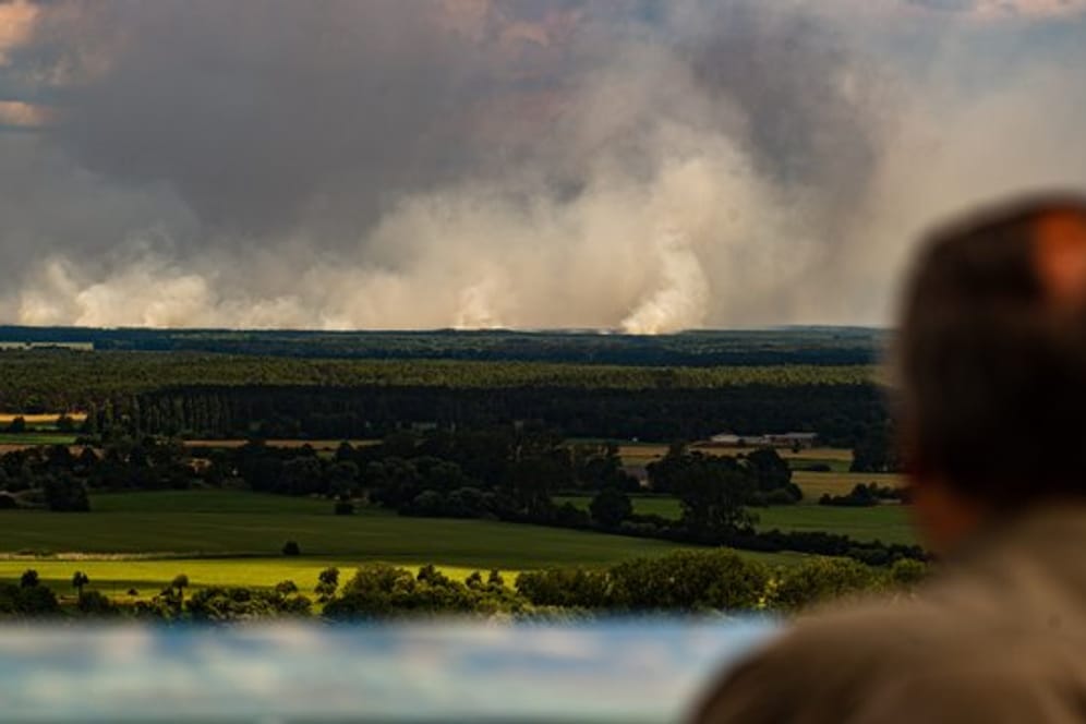 Ein Mann blickt von einem Aussichtsturm von Niedersachsen aus über die Elbe auf den Waldbrand bei Lübtheen in Mecklenburg-Vorpommern.