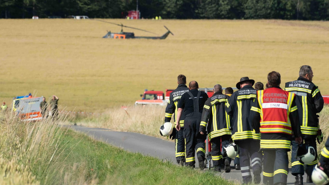 Feuerwehrleute auf dem Weg zur Absturzstelle des Hubschraubers in Aerzen.