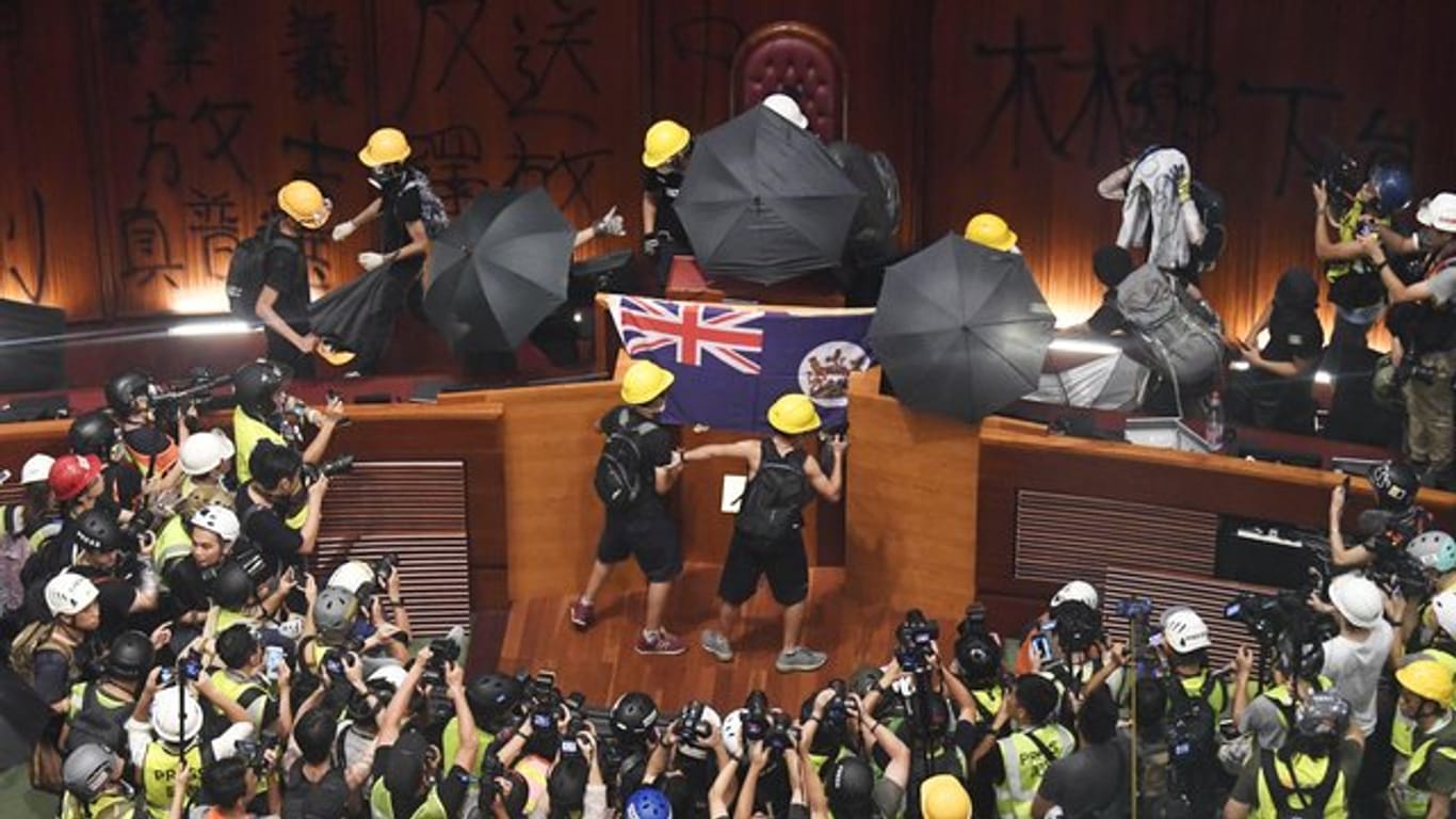 Demonstranten hissen im Hongkonger Parlament die Flagee der ehemaligen britischen Kolonie.