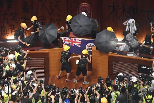Demonstranten hissen im Hongkonger Parlament die Flagee der ehemaligen britischen Kolonie.