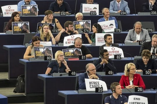"Seenotrettung ist kein Verbrechen" - Mitglieder des EU-Parlaments zeigen Schilder zur Unterstützung der Kapitänin des Rettungsschiffes "Sea-Watch 3".