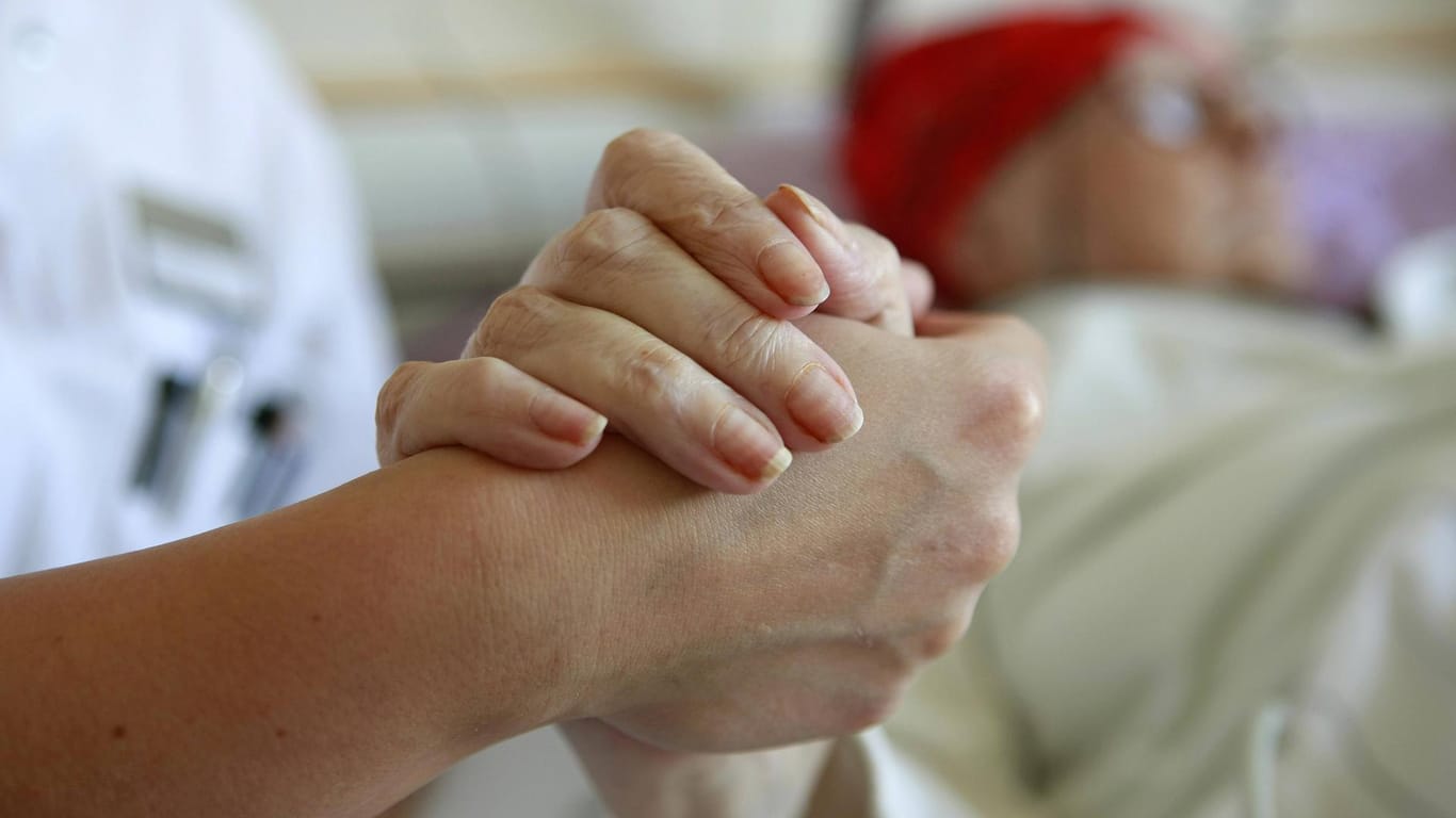 Pflegerin hält Hand eines Patienten: Vorinstanzen hatten Mediziner vom Vorwurf eines Tötungsdeliktes freigesprochen und mit dem Patientenwillen argumentiert. (Symbolfoto)