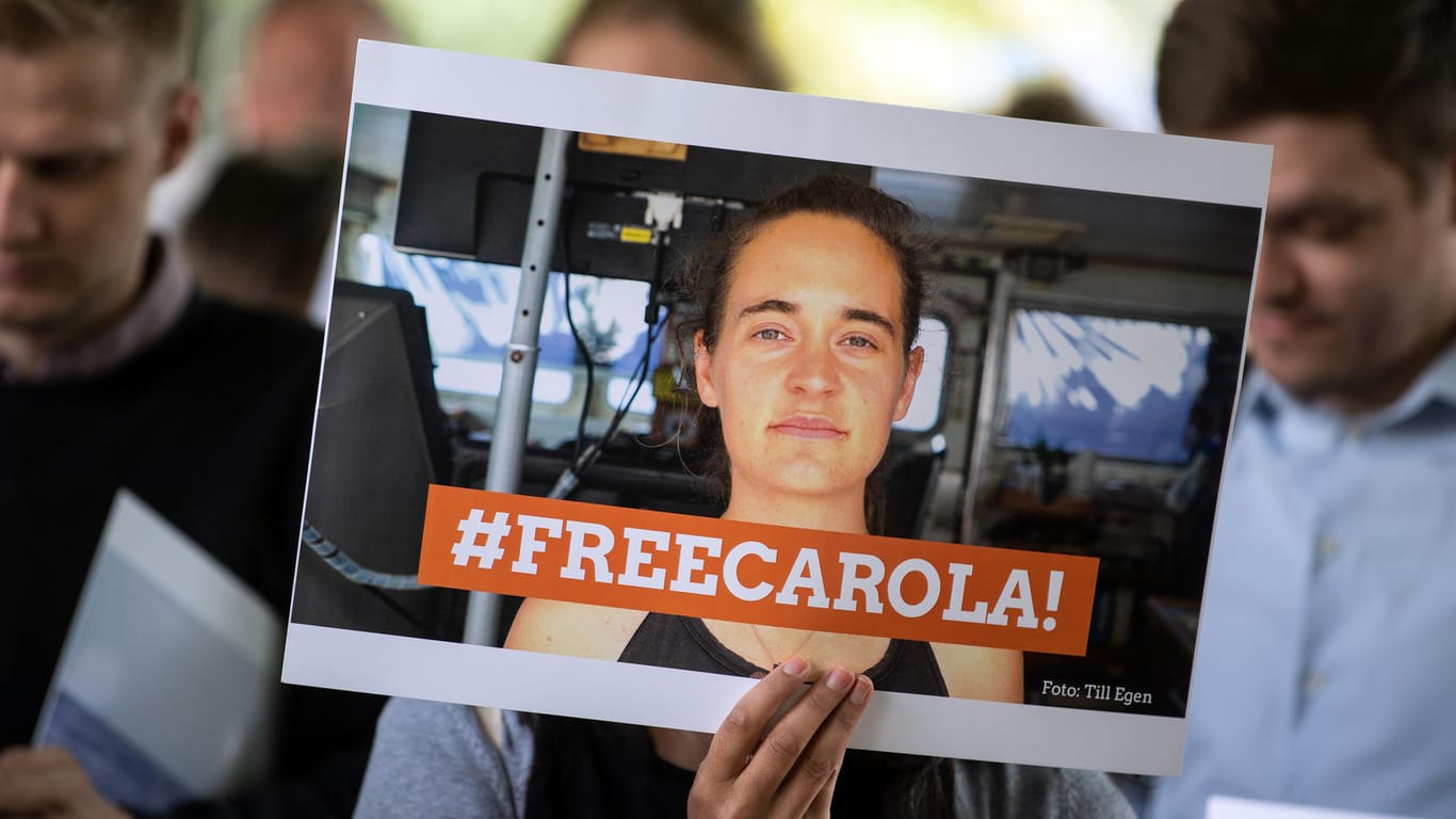 Eine Demonstrantin hält ein Bild von der Sea-Watch-Kapitänin Carola Rackete in der Hand: Am 9. Juli soll sie erneut vernommen werden.