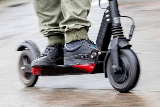 Am besten die Füße hintereinander auf das schmale Trittbrett des E-Tretrollers stellen.