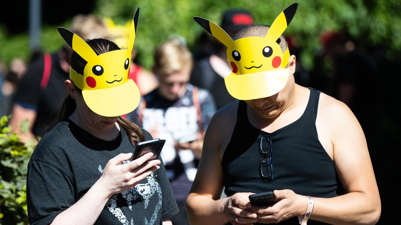 Teilnehmer mit Pokemon-Sonnenschutz spielen im Westfalenpark: Zu einem "Pokémon Go"-Fest in Dortmund werden ab Donnerstag Zehntausende Fans aus ganz Deutschland und Europa erwartet.