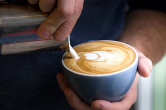 Barista bereitet einen Flat White zu: Charakteristisch für die Kaffeespezialität ist der feine Milchschaum.