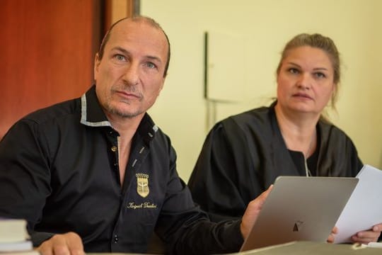 Der selbst ernannte "König von Deutschland" sitzt neben seiner Anwältin im Landgericht in Hof.