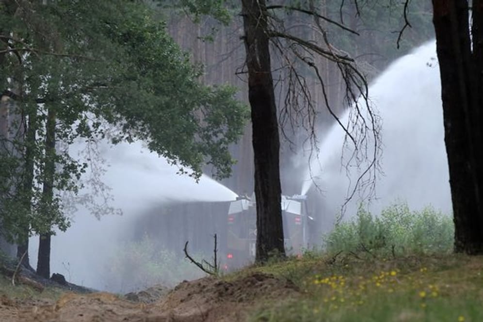 Ein Wasserwerfer der Bundespolizei spritzt Löschwasser in der Nähe der Ortschaft Alt Jabel auf Glutnester in einem abgebrannte Waldstück.