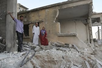 Bürger begutachten den Schaden an einem Haus, das bei Luftangriffen auf den Ort Muhambai zerstört wurde.