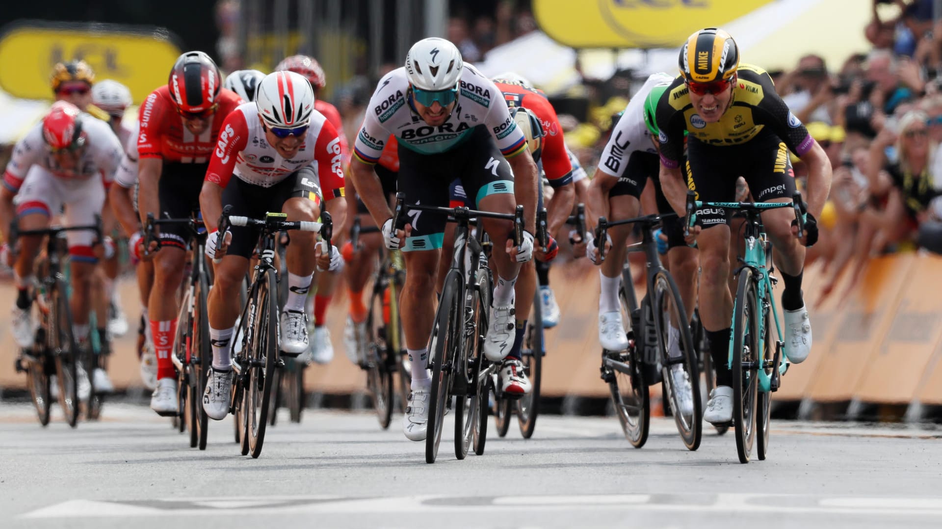 Mike Teunissen (r.) besteht im Zielsprint in Brüssel gegen Superstar Peter Sagan (M.): Der Niederländer übernimmt damit auch als Erster das Gelbe Trikot.