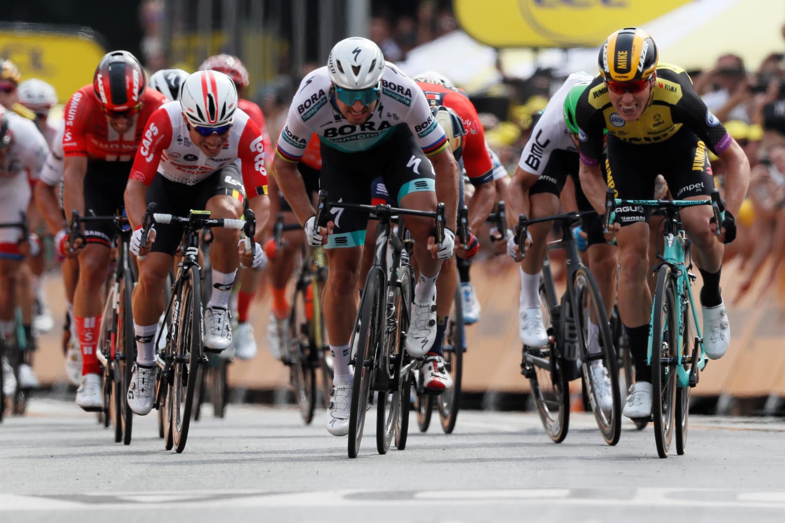 Mike Teunissen (r.) besteht im Zielsprint in Brüssel gegen Superstar Peter Sagan (M.): Der Niederländer übernimmt damit auch als Erster das Gelbe Trikot.