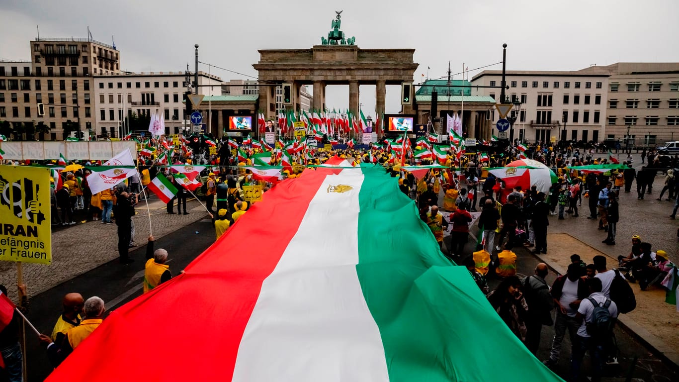 Iran-Flagge vor dem Brandenburger Tor (Archivbild): Der Berliner Senat hat die Aussetzung der Abschiebungsverfahren in den Iran erklärt.