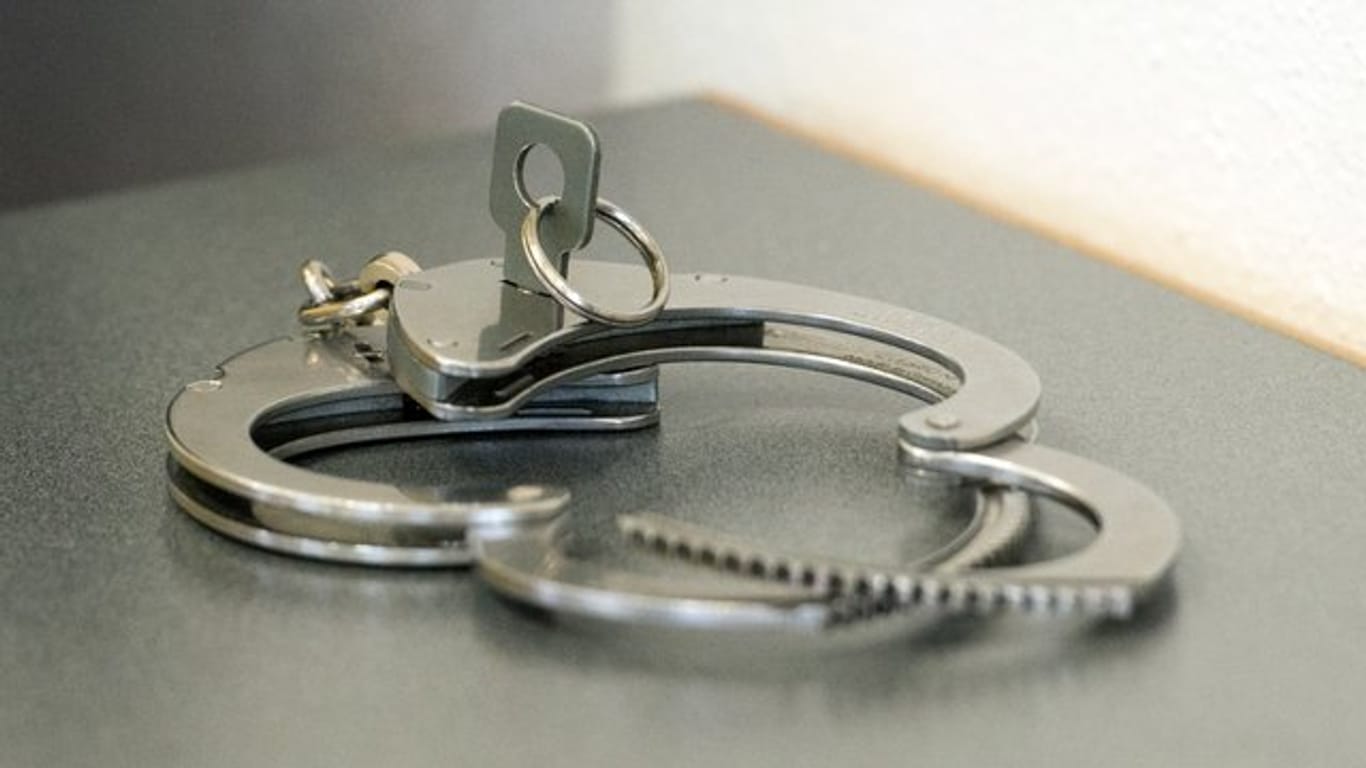 Handschellen liegen auf einem Tisch: Nach einem Tötungsdelikt in Frankfurt wurde ein Mann festgenommen. (Symbolbild)