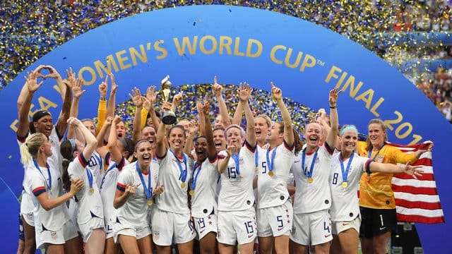 Carli Lloyd (M) hält den WM-Pokal inmitten der jubelnden US-Spielerinnen. Carli Lloyd (M) hält den WM-Pokal inmitten der jubelnden US-Spielerinnen.