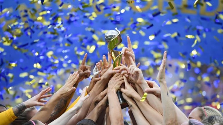 Die US-Spielerinnen feiern ihren Sieg und halten gemeinsam den WM-Pokal nach oben.