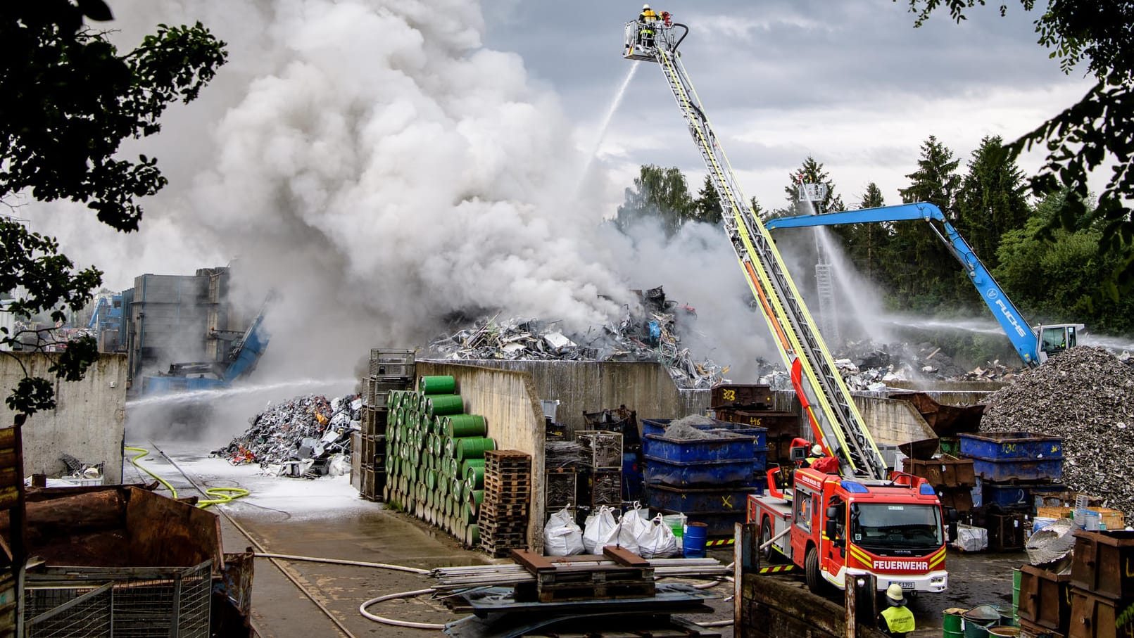 Ein Schrotthof in München: Die Feuerwehr löscht ein Feuer auf einem Recyclinghof im Stadtteil Aubing-Lochhausen. Die Feuerwehr ist seit der Nacht mit rund 100 Einsatzkräften im Einsatz. Ein Schrotthof in München: Die Feuerwehr löscht ein Feuer auf einem Recyclinghof im Stadtteil Aubing-Lochhausen. Die Feuerwehr ist seit der Nacht mit rund 100 Einsatzkräften im Einsatz.