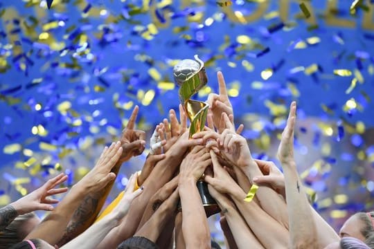 Die US-Spielerinnen feiern ihren Sieg und halten gemeinsam den WM-Pokal nach oben.