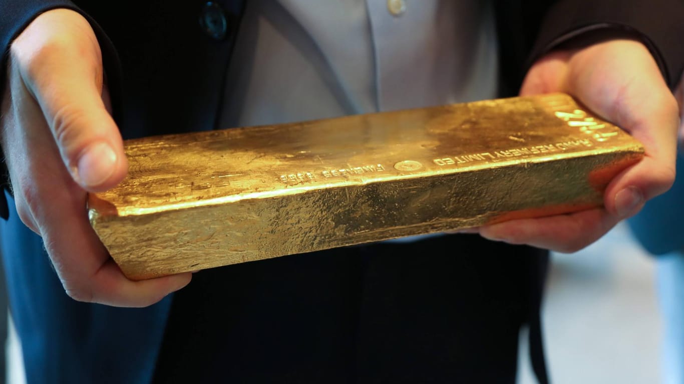 Ein Mann hält einen Goldbarren in den Händen: Die Polizei warnt vor Fake-Shops im Internet, die mit dem An- und Verkauf von Gold werben.