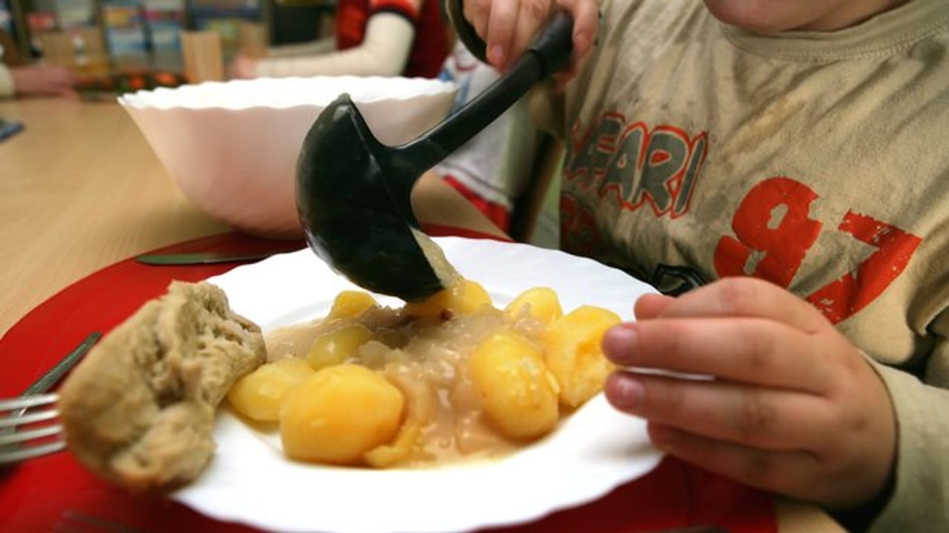 Ein Junge nimmt sich beim Mittagstisch des Kinderschutzbundes in Schwerin Soße für die Kartoffeln.