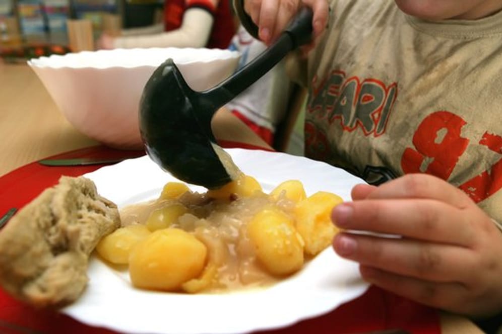 Ein Junge nimmt sich beim Mittagstisch des Kinderschutzbundes in Schwerin Soße für die Kartoffeln.