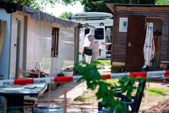 Bei den Durchsuchungen auf einer Parzelle auf dem Campingplatz in Lügde tragen Polizeibeamte der Kriminaltechnik eine Kiste in die Campinghütte eines neuen Tatverdächtigen.