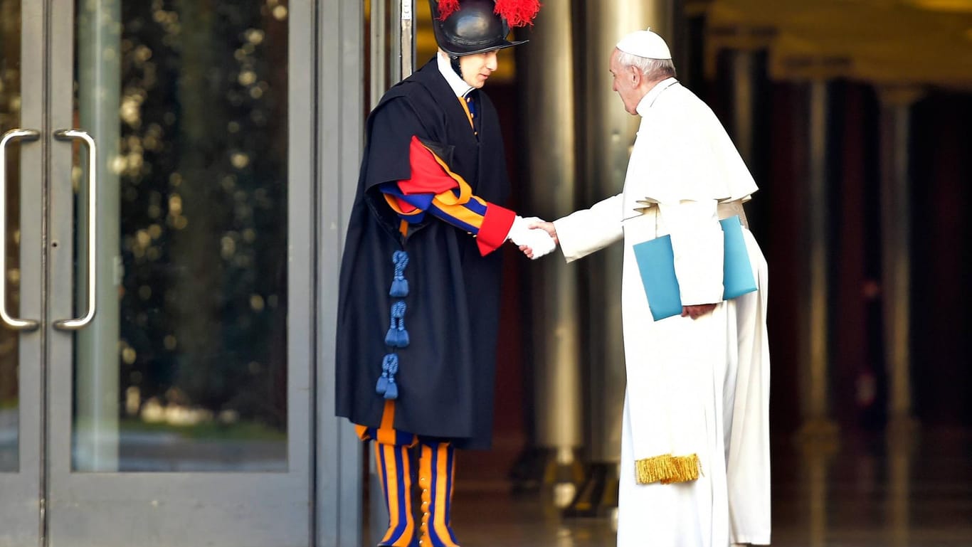 Papst Franziskus begrüß auf dem Weg zur Bischofskonferenz ein Mitglied der Päpstlichen Schweizergarde.