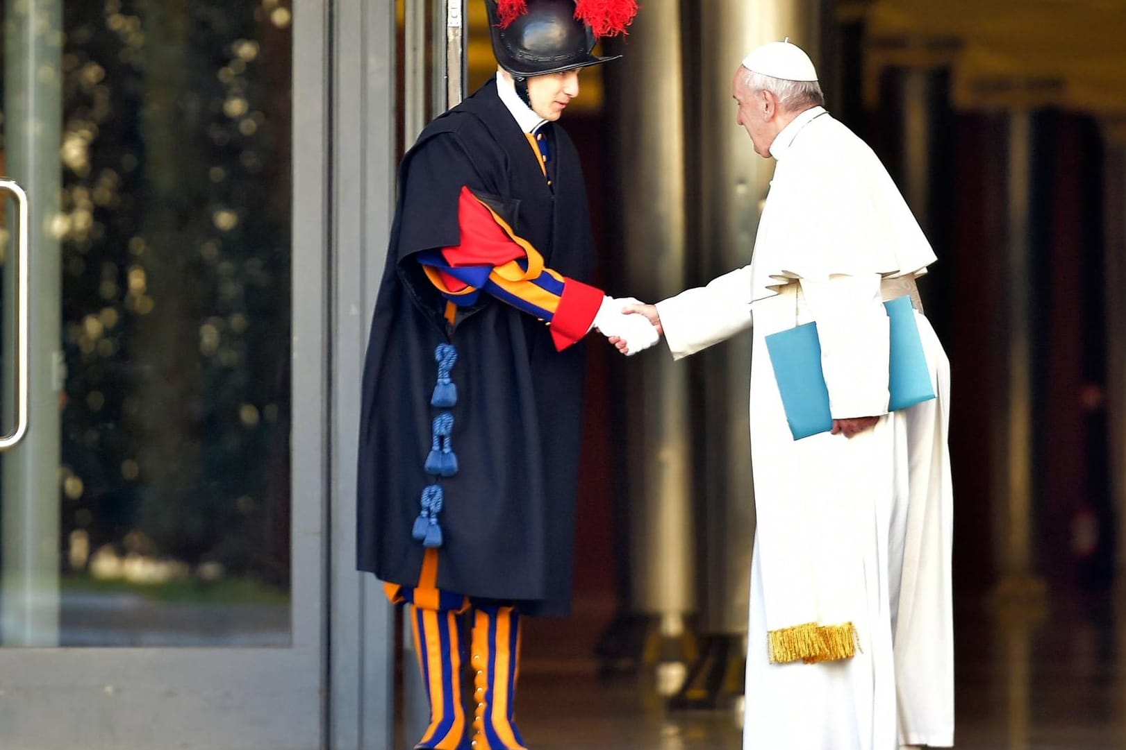Papst Franziskus begrüß auf dem Weg zur Bischofskonferenz ein Mitglied der Päpstlichen Schweizergarde.