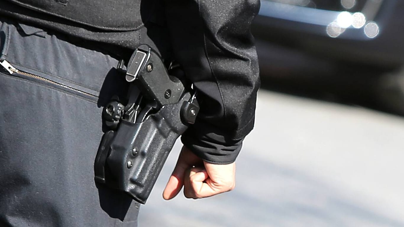 Ein Polizist mit Schusswaffe: Der 19-Jährige wurde mit einem Haftbefehl gesucht.