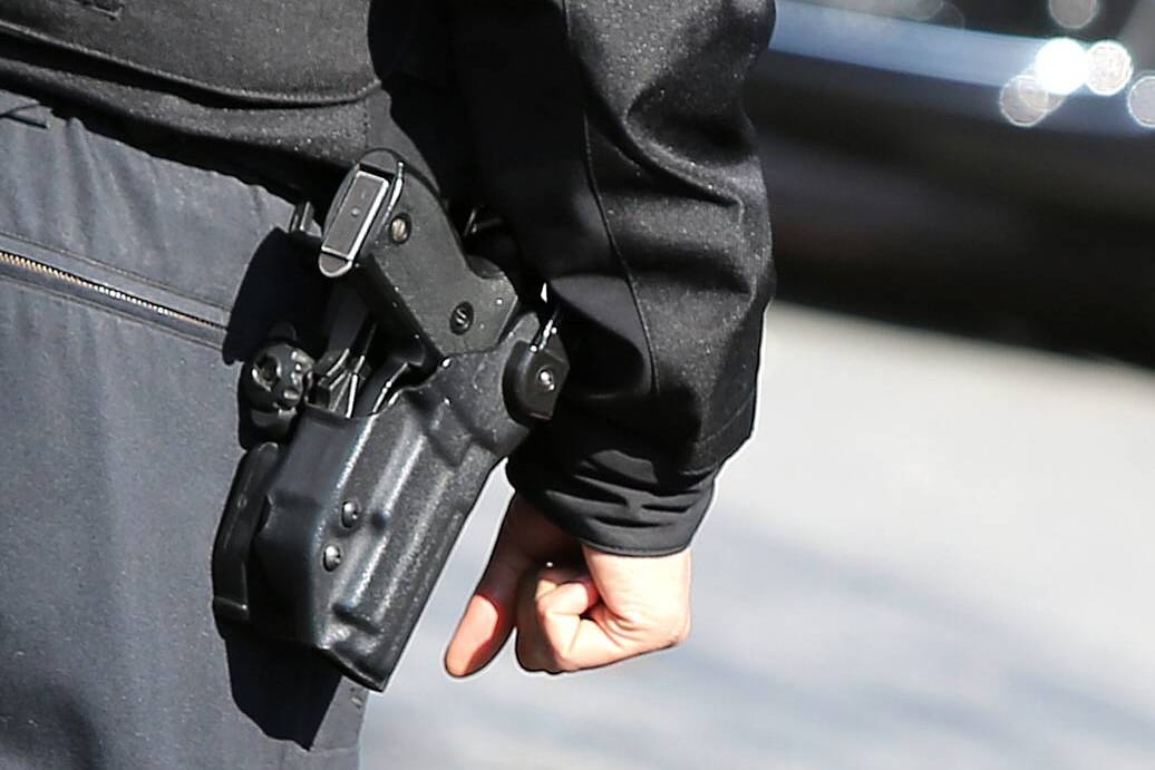 Ein Polizist mit Schusswaffe: Der 19-Jährige wurde mit einem Haftbefehl gesucht.