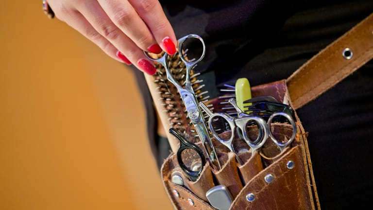 Das Handwerkszeug einer Friseurin in einer Gürteltasche: Friseure suchen händeringend Fachkräfte.