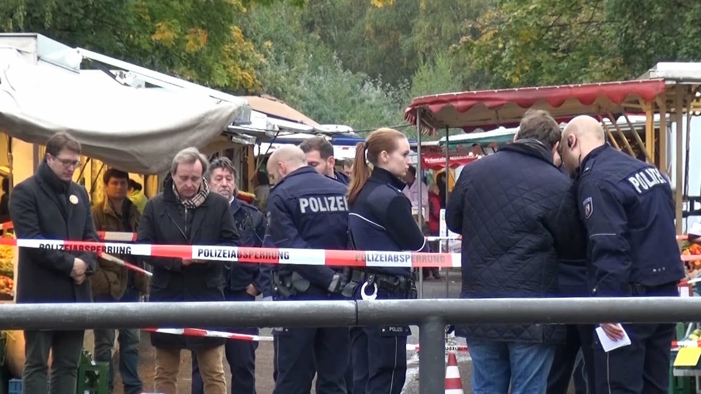 Polizisten am Tatort des Messerangriffs auf die spätere Kölner Oberbürgermeisterin Henriette Reker.