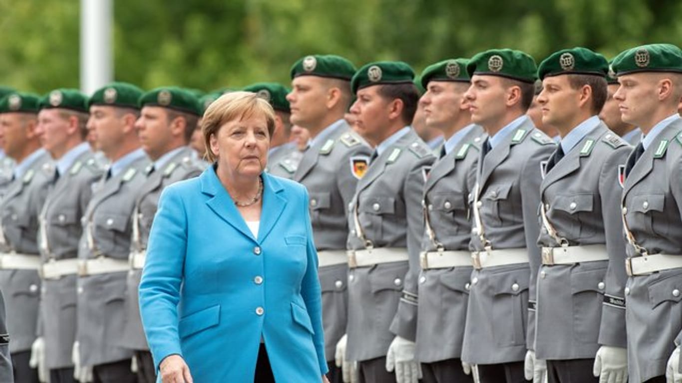 Kanzlerin Merkel vor Soldaten des Wachbataillons im Ehrenhof des Bundeskanzleramts.