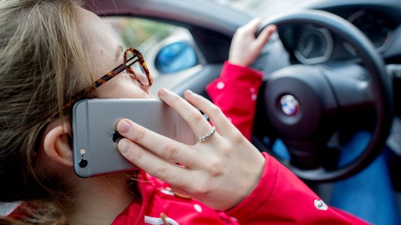 Nur noch schnell einen Anruf entgegennehmen: Viele Autofahrer können selbst am Steuer nicht auf ihr Handy verzichten.