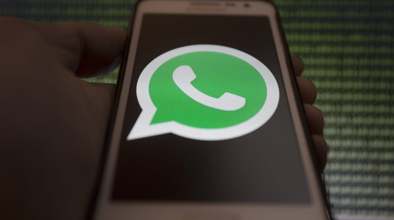 Jemand hält ein Smartphone mit dem WhatsApp-Logo: Forscher warnen vor einer Android-Malware namens "Agent Smith", die auch WhatsApp befallen kann.