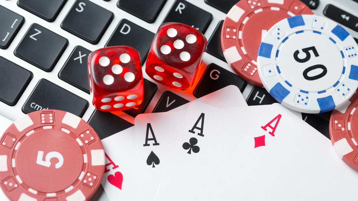 Spielkarten liegen auf einer Tastatur: Die Software "Pluribus" wurde zunächst erprobt und trainiert, indem sie "No Limit Texas Hold'em" gegen fünf Kopien von sich selbst spielte.