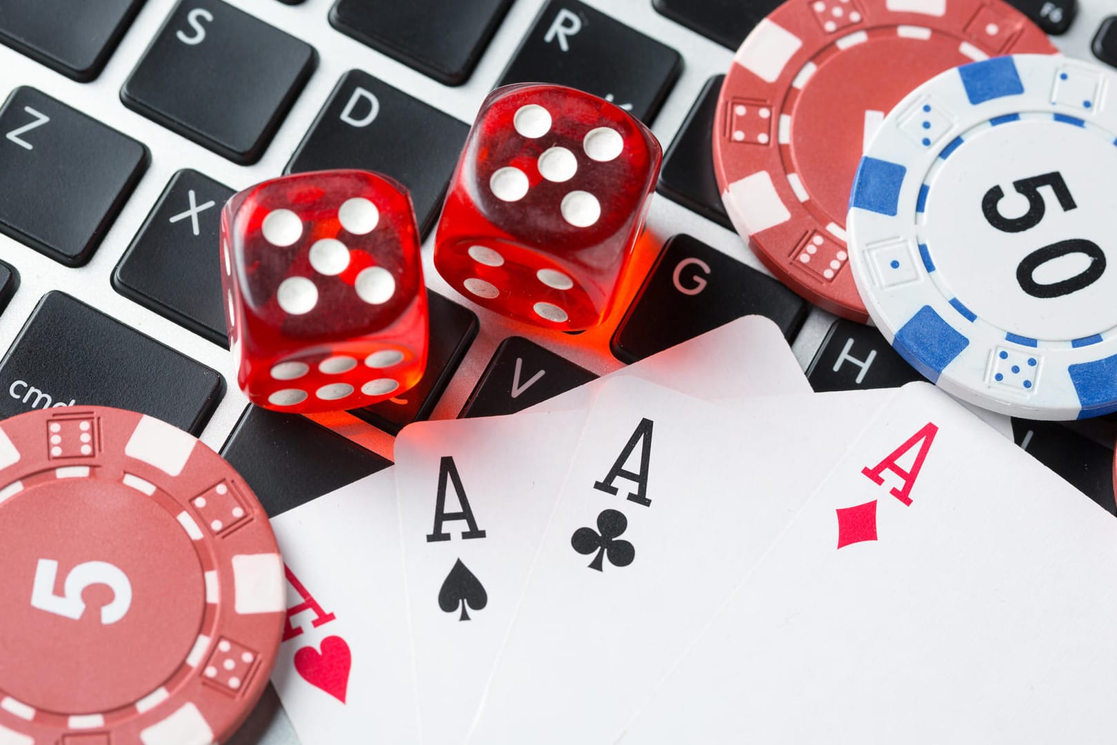 Spielkarten liegen auf einer Tastatur: Die Software "Pluribus" wurde zunächst erprobt und trainiert, indem sie "No Limit Texas Hold'em" gegen fünf Kopien von sich selbst spielte.