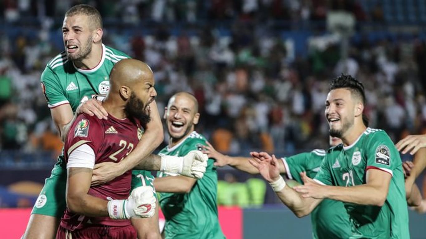 Algeriens Keeper Rais M'Bolhi(l) feiert mit seinen Teamkollegen das gegen Elfenbeinküste gewonnene Elfmeterschießen.