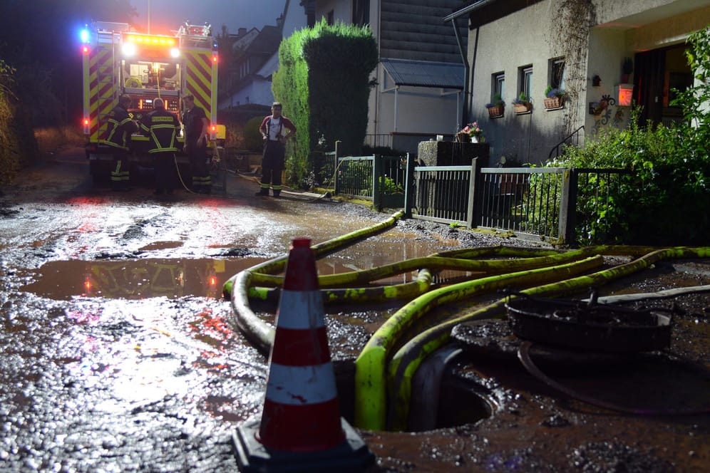 Feuerwehrleute pumpen einen Keller im Stadtteil Olewig leer: Ein heftiges Unwetter mit starkregen und Hagel war über die Region hinweggefegt und flutete zahlreiche Straßen und Keller.