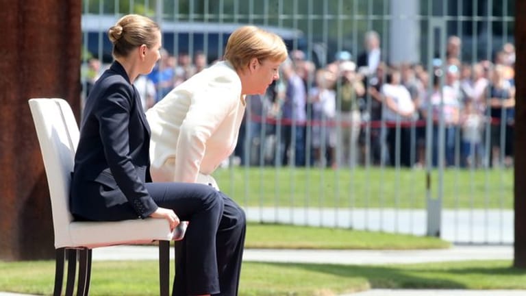 In sitzender Position verfolgen Angela Merkel und die dänische Ministerpräsidentin Mette Frederiksen das Abspielen der Nationalhymnen.