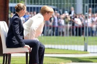 In sitzender Position verfolgen Angela Merkel und die dänische Ministerpräsidentin Mette Frederiksen das Abspielen der Nationalhymnen.