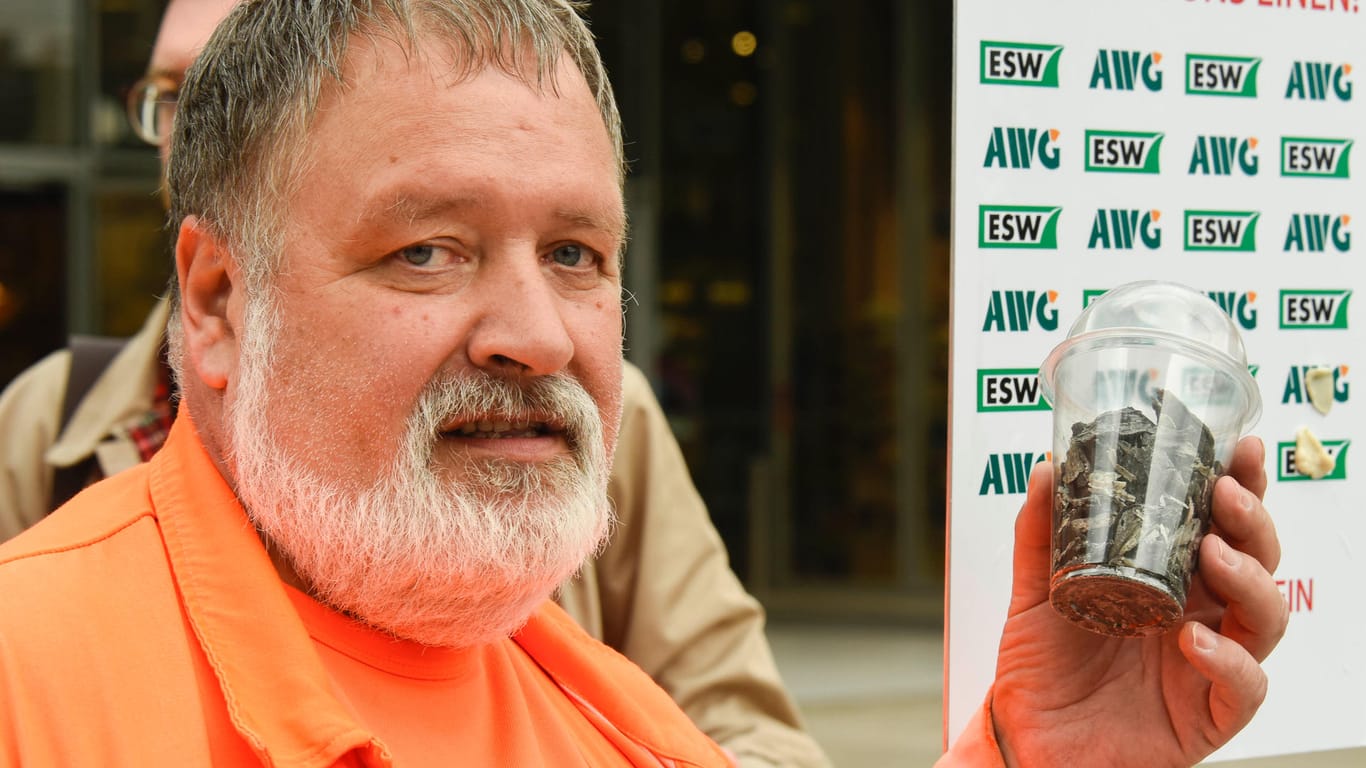 Friedhelm Nick, Straßenreiniger in Wuppertal vom ESW, zeigt vor der "Gum-Wall" abgekratzte Kaugummis: Seine Forderung: "Kaugummis gehören in den Abfalleimer."
