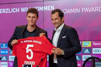 Weltmeister Benjamin Pavard (l) wird von Bayern-Sportdirektor Hasan Salihamidzic begrüßt.