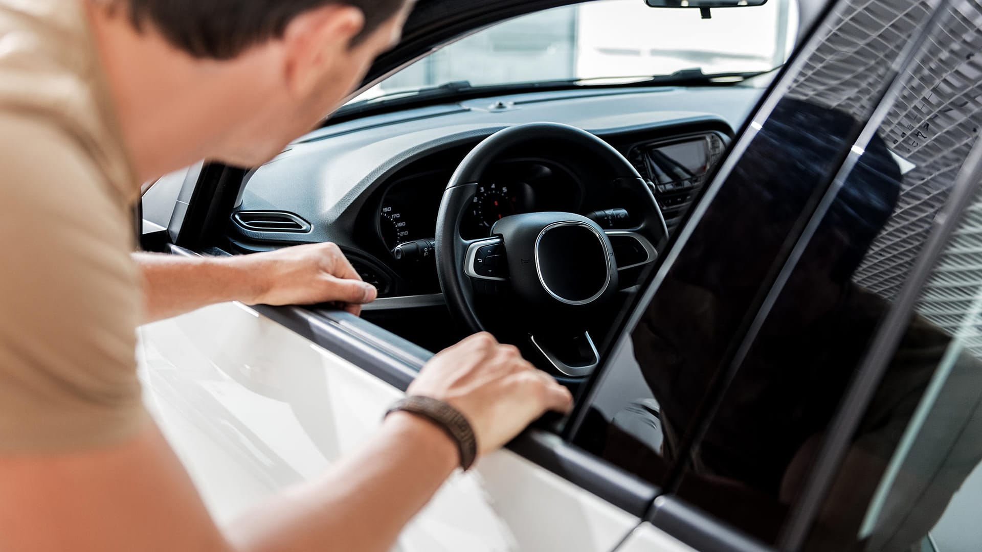 Mann begutachtet Auto: Eine Besichtigung sollte immer im Hellen stattfinden, um Schäden leichter zu erkennen.