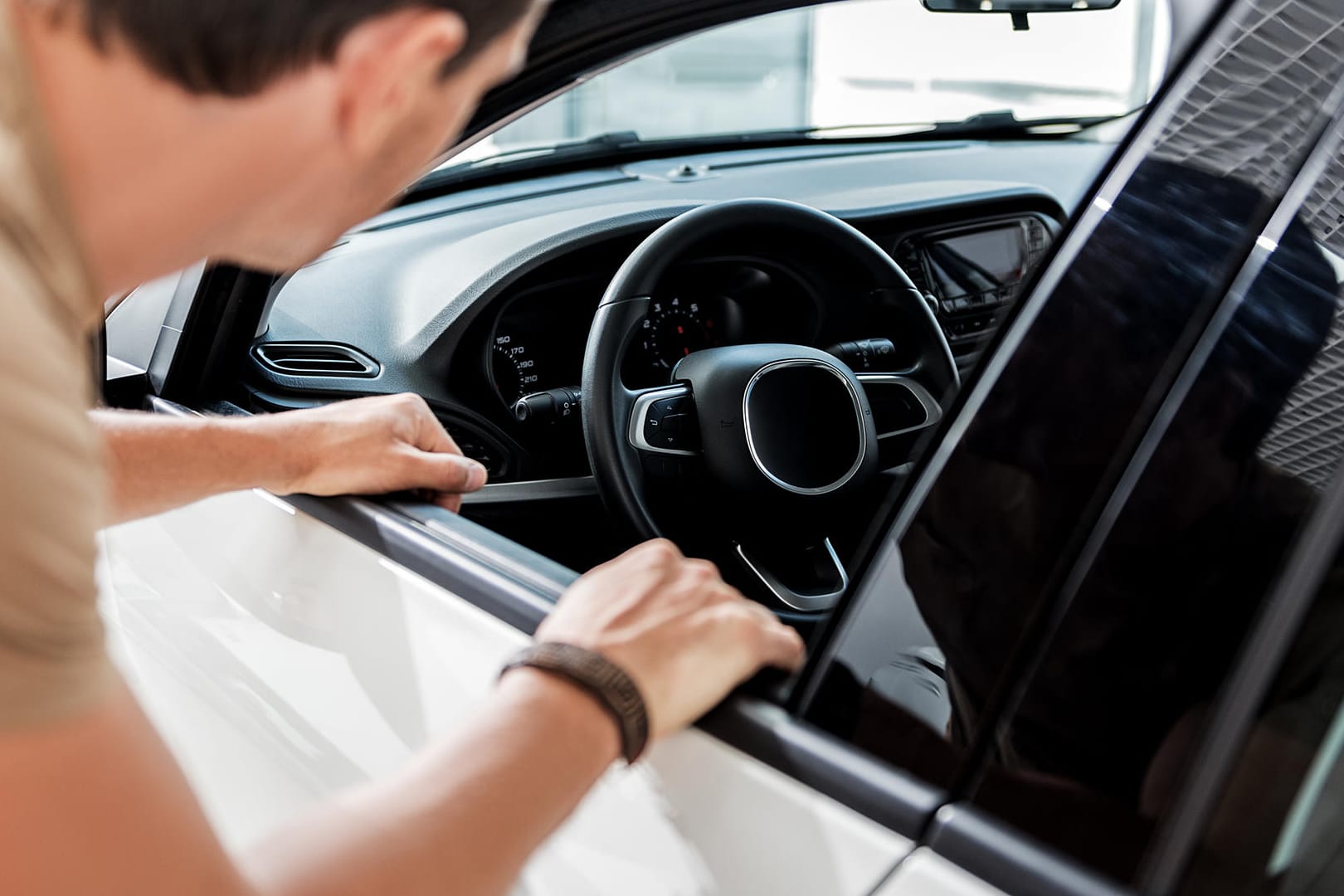 Mann begutachtet Auto: Eine Besichtigung sollte immer im Hellen stattfinden, um Schäden leichter zu erkennen.