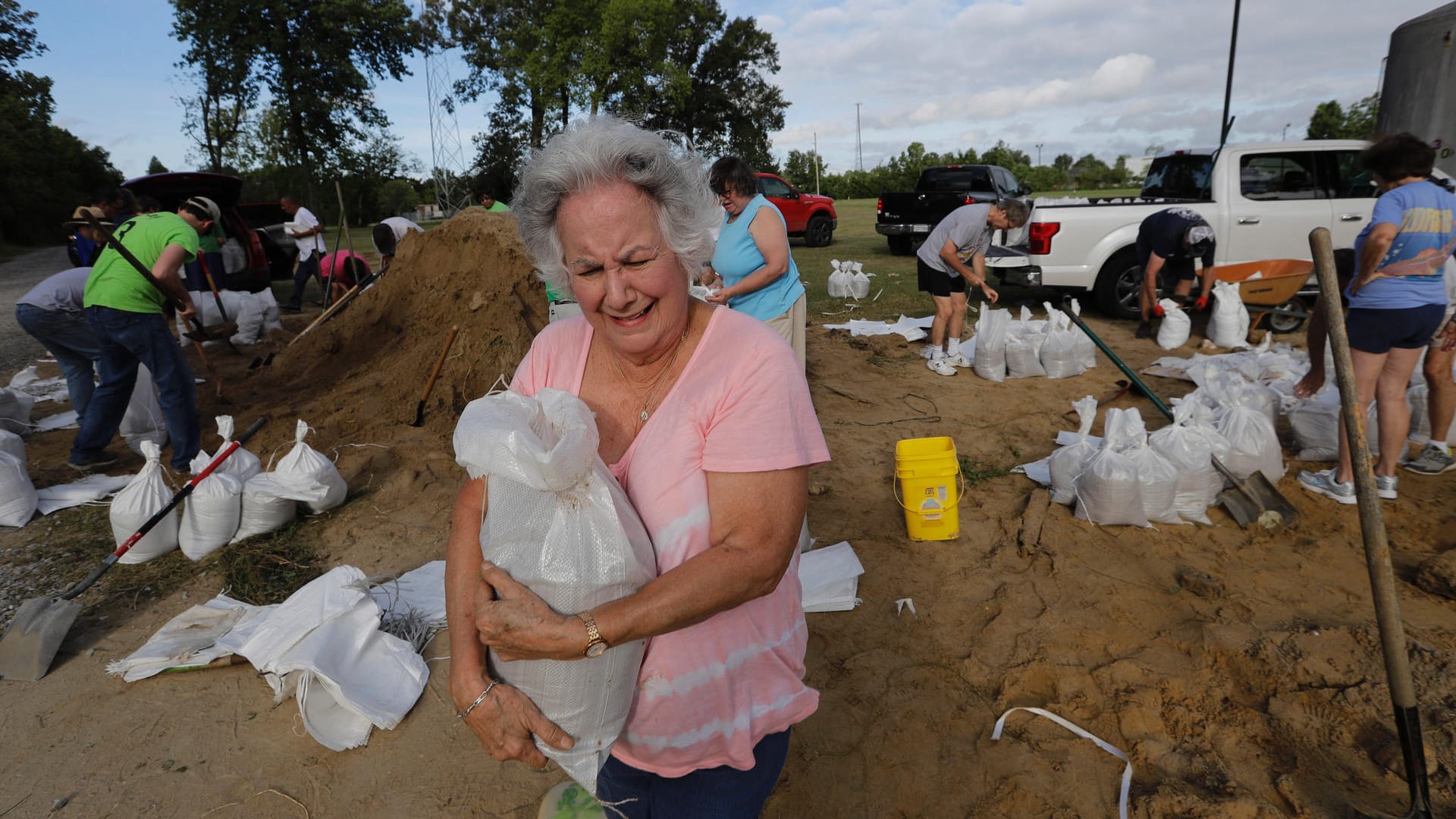 Eine Frau trägt eine Sandsack: Erste Regionen sind bereits überschwemmt worden, Sandsäcke sollen das Schlimmste verhindern.