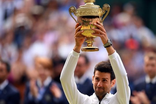 Novak Djokovic hält die Wimbledon-Trophäe zum fünften Mal in seinen Händen.