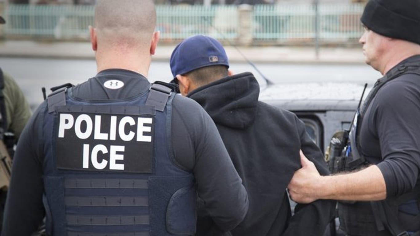 Polizisten der US-Immigration and Customs Enforcement Zollbehörde führen bei einer früheren Aktion einen Festgenommenen ab.
