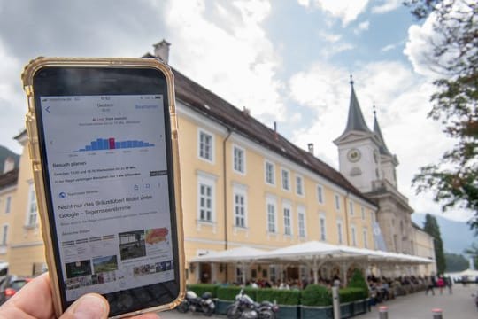 Ein Smartphone mit einer Google-Anzeige wird vor das Bräustüberl am Tegernsee gehalten: Die Gaststätte klagt gegen den Internet-Riesen.